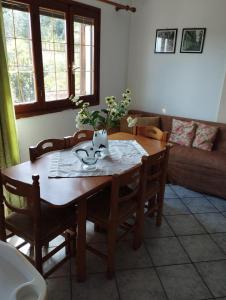 a dining room table with chairs and a wooden table with a vase at Kanakades Valley View House in Kanakádes