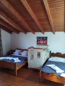 a bedroom with two beds and a wooden ceiling at Kanakades Valley View House in Kanakádes