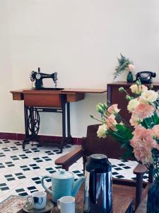 a desk with a camera and a table with flowers at Thanh Xuân House in Xuan An