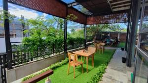 a patio with grass and a table and chairs at SMARANALA in Nusa Dua