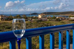 a wine glass sitting on a balcony with a view at Meli Apartments near sea side in Kythira