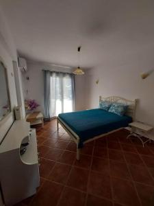 a bedroom with a bed and a tiled floor at Meli Apartments near sea side in Kythira