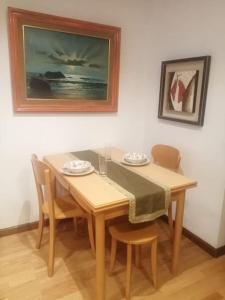 a dining room table and chairs with a painting on the wall at Apartamento con terraza a 800 m playa in Gijón