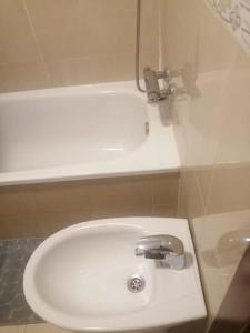 a bathroom with a white sink with a faucet at Apartamento con terraza a 800 m playa in Gijón