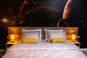 una camera da letto con un grande letto con due cuscini gialli di Galaxy Apartments a Belgrado