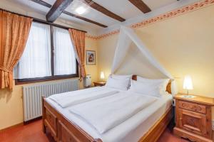 ein Schlafzimmer mit einem Himmelbett und einem Fenster in der Unterkunft Hotel Weiler in Oberwesel