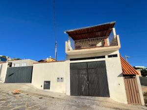 a white building with a balcony on top of it at Casa Por do Sol. in São Thomé das Letras