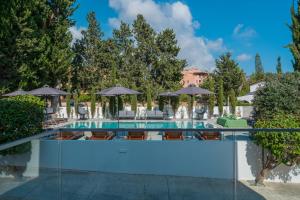 a swimming pool with chairs and umbrellas at Silver Park in Paphos