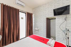 Un dormitorio con una cama con un televisor en la pared. en RedDoorz Syariah near Green Park Jatiwarna, en Bekasi 38 fotos más