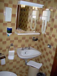 a bathroom with a sink and a mirror and a toilet at Lago Maggiore in Lesa