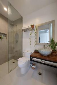 a bathroom with a toilet and a sink and a shower at Sea Green Boutique Rooms in General Luna