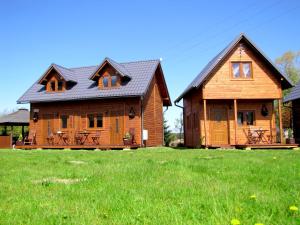 オストロボにあるHoliday home Domki u Asiの緑草原の大木造家屋