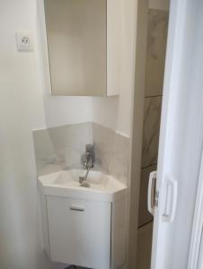 a bathroom with a sink and a mirror at Au Tromp l'oeil Studio ou T2 in Sainte-Marie-la-Mer