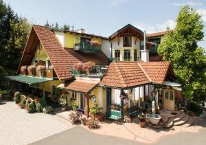 una casa con un sacco di fiori davanti di Thermenhof PuchasPLUS Loipersdorf a Jennersdorf