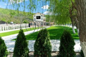 a playground in a park with trees and a swing at Vega resort Restaurant & Lodge in Orşova