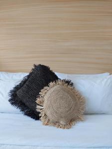 a pillow on top of a bed with a black blanket at Sea Green Boutique Rooms in General Luna