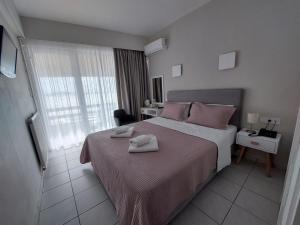 1 dormitorio con 1 cama con 2 toallas en Hotel Avra, en Preveza