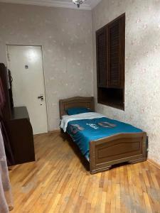 een slaapkamer met een bed en een houten vloer bij Old Houme in Old Tbilisi in Tbilisi City