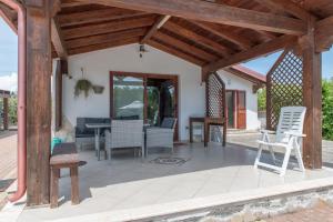 um pátio com uma pérgola de madeira e cadeiras em Countryside villa with pool em San Sperate