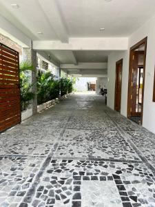 a hallway of a building with a stone floor at ANAND Beach Guesthouse by Moonrocks in Mahabalipuram