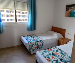 a bedroom with two beds and a window at Gemelos 22 - Siroco in Benidorm