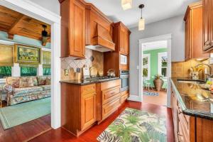 a kitchen with wooden cabinets and a living room at Welcome to Casa Kanuga, The Secret Gem of WPB! in West Palm Beach