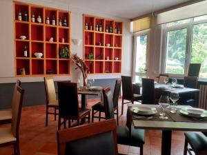 uma sala de jantar com mesas e cadeiras e armários vermelhos em Locanda Ostu di San giacu em Boves