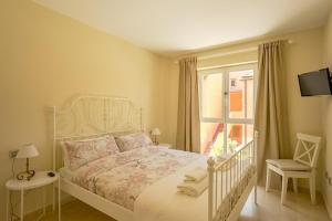 sypialnia z białym łóżkiem i oknem w obiekcie Luxury apartment Sotogrande w mieście San Roque +22 zdjęcia