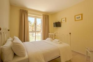 sypialnia z białym łóżkiem i oknem w obiekcie Luxury apartment Sotogrande w mieście San Roque