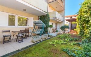 a patio with a table and chairs in a yard at Apartment Bjanka in Pakoštane