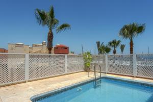 basen z ogrodzeniem i palmami w obiekcie Luxury apartment Sotogrande w mieście San Roque