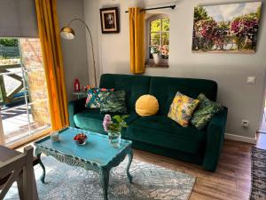 a living room with a green couch and a table at Hubertówka in Somonino