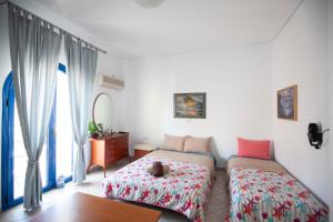 a bedroom with two beds and a table and a mirror at Hara's Studio in Perdika