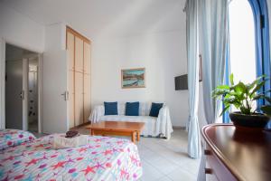 a hotel room with a bed and a couch at Hara's Studio in Perdika