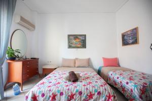 a bedroom with two beds with a stuffed animal on the bed at Hara's Studio in Perdika
