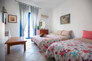 a hotel room with two beds and a table at Hara's Studio in Perdika