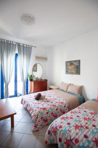a bedroom with two beds and a cat laying on the bed at Hara's Studio in Perdika