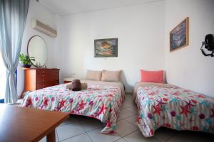 a bedroom with two beds with a teddy bear sitting on them at Hara's Studio in Perdika