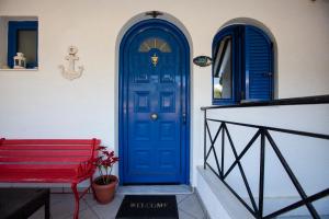 two blue doors on a building with a red bench at Hara's Studio in Perdika