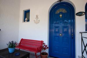 a red bench sitting next to a blue door at Hara's Studio in Perdika