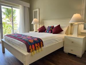 a bedroom with a large bed with two night stands and two lamps at Hotel Palmera Bayahibe in Bayahibe