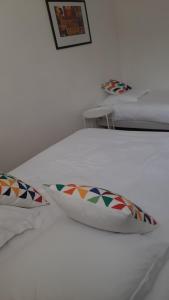 a white bed with two pillows on it at La Mansarde in Saint-Émilion