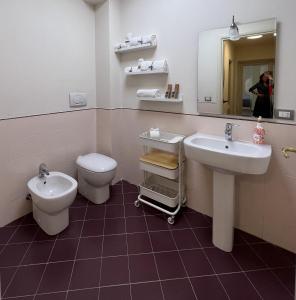 a bathroom with a sink and a toilet and a mirror at La Suite di Chiara in Livorno
