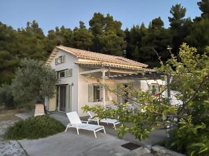 a house with two white chairs in front of it at Thymari House in Milia