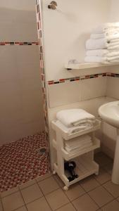 a bathroom with a shower and a sink and towels at La Mansarde in Saint-Émilion