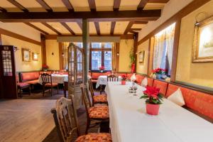 a long table in a restaurant with tables and chairs at Hotel Weiler in Oberwesel