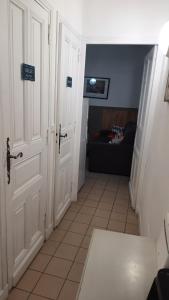 a hallway with two white doors and a couch at La Mansarde in Saint-Émilion