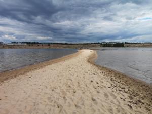 a beach with sand and water on a cloudy day at Northern Lights - Cozy apartment, sisältää liinavaatteet in Kalajoki