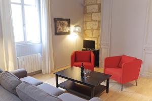 a living room with two red chairs and a coffee table at Chartres - Appartement 1 chambre avec ascenseur in Bordeaux