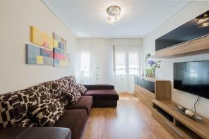 a living room with a couch and a flat screen tv at Apartamento céntrico Candás in Candás